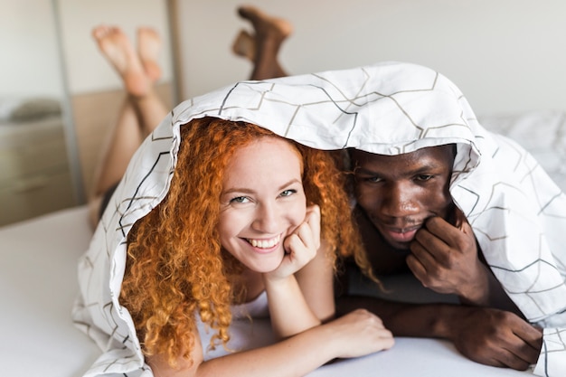 Free Photo front view of couple snuggling under the covers