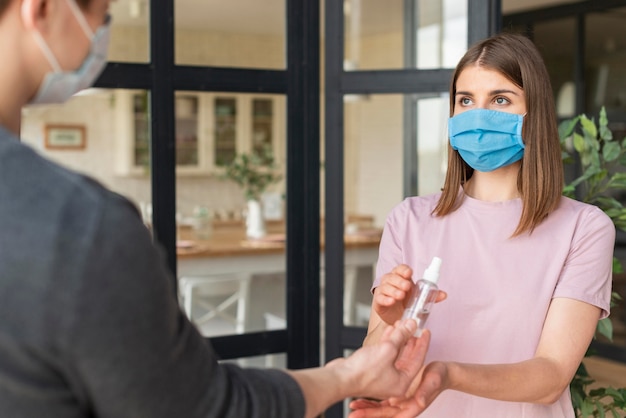 Front view of couple using disinfectants