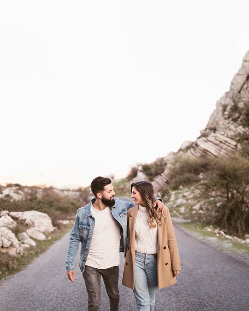 Front view couple walking on a road