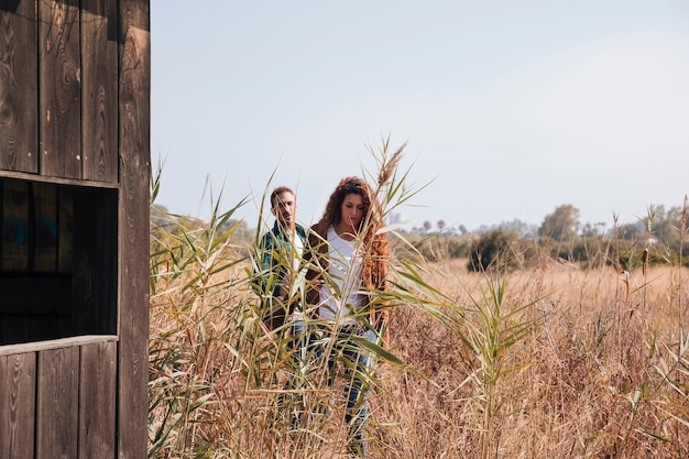 Free photo front view couple walking in a wheat field