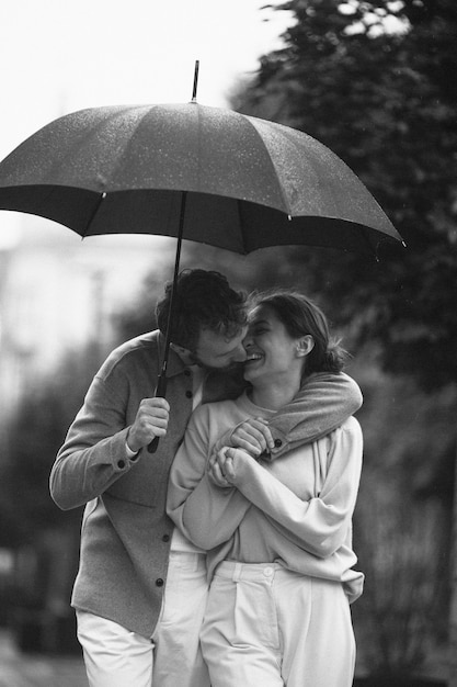 Front view couple walking with umbrella