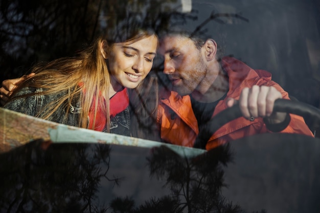 Free Photo front view of couple with map inside car going on a road trip together