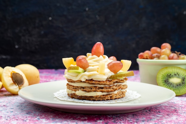 Front view of cream cake with fresh sliced fruits on the dark surface