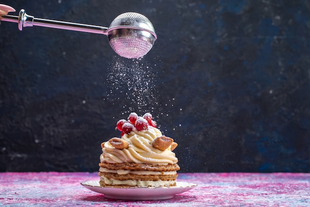 Front view of cream waffle cake with cranberries on the dark surface