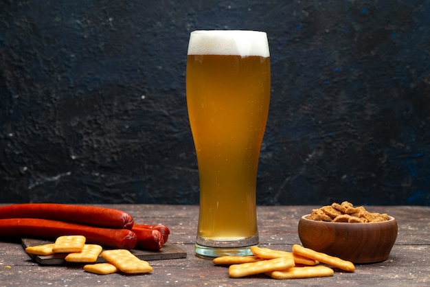 Front view of crisps and crackers along with beer on the dark surface