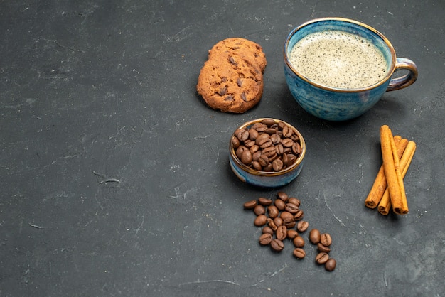 Front view a cup of coffee bowl with coffee seeds cinnamon sticks biscuits on dark isolated background free place