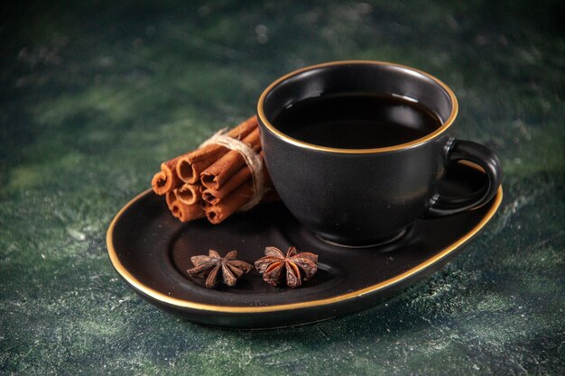 front view cup of tea in black cup and plate on dark surface sugar ceremony glass breakfast cake dessert color sweet cinnamon