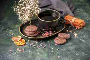 Free photo front view cup of tea in black cup and plate with biscuits on dark surface color sugar breakfast dessert cake cookie ceremony