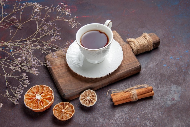 Front view cup of tea inside glass cup with plate on dark desk tea ceremony glass drink darkness color