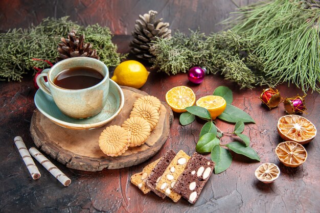 Front view cup of tea with cookies and cake on dark background