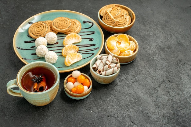 Free photo front view cup of tea with cookies and candies on grey table cookie cake biscuit tea