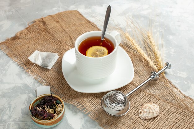 Front view cup of tea with lemon slice on white surface