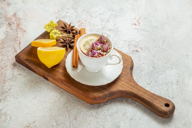 Free photo front view cup of tea with lemon slices on a white space