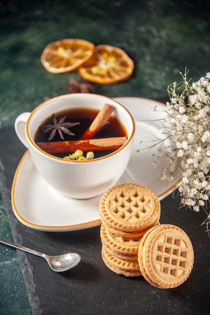 Free photo front view cup of tea with sweet biscuits on dark surface bread drink ceremony glass sweet breakfast cake color photo morning