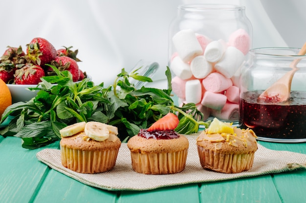 Free photo front view cupcakes with bananas strawberries lemon and mint with marshmallows in a jar