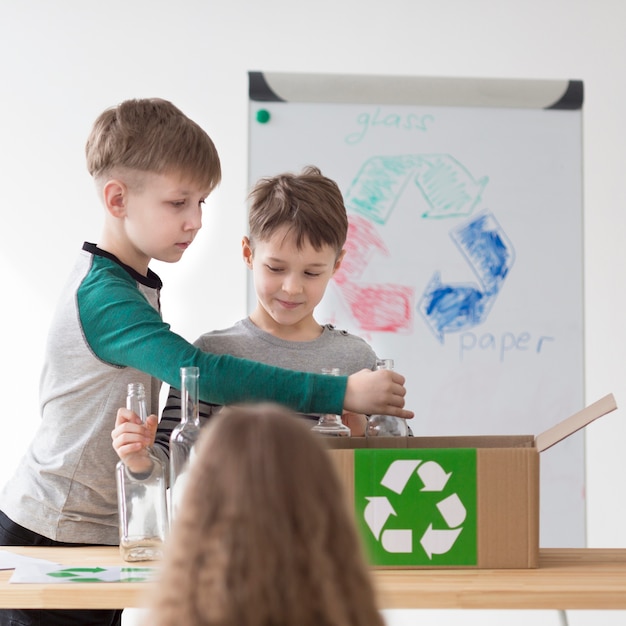 Free photo front view cute children learning how to recycle