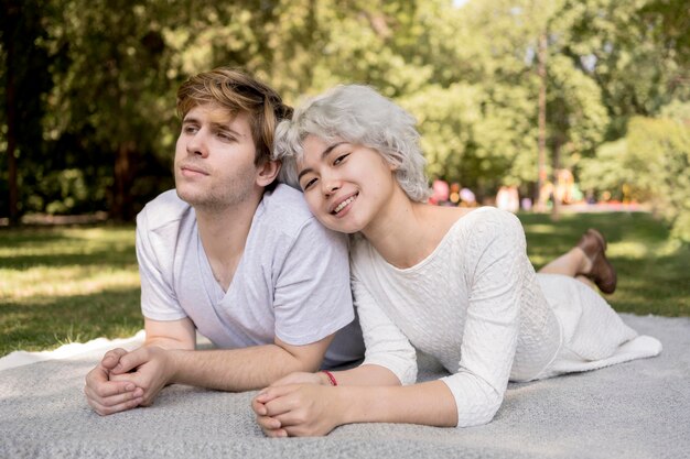 Front view of cute couple outdoors on a blanket