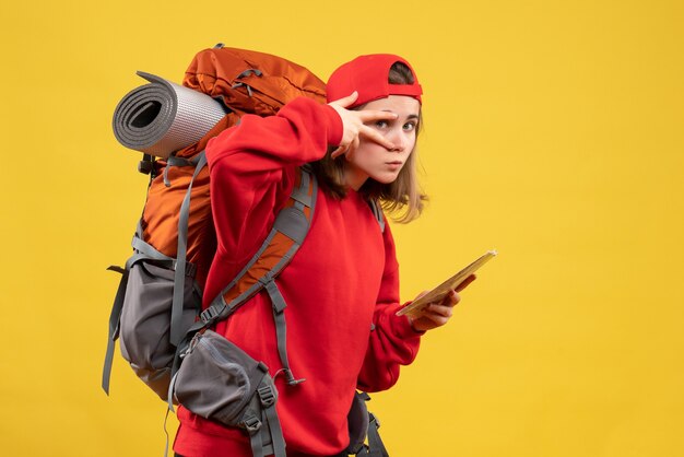 Front view cute female backpacker holding travel map