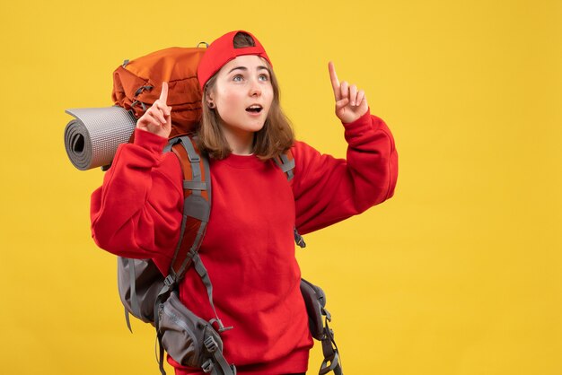 Free photo front view cute female traveler with backpack pointing fingers up