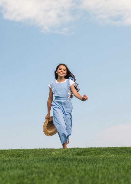 Front view cute girl walking on grass