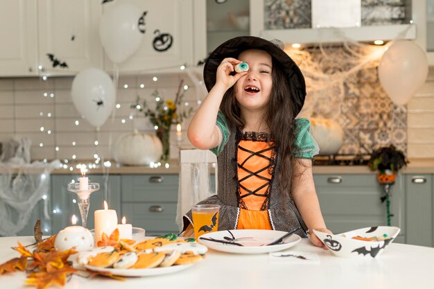 Front view of cute little girl with witch costume