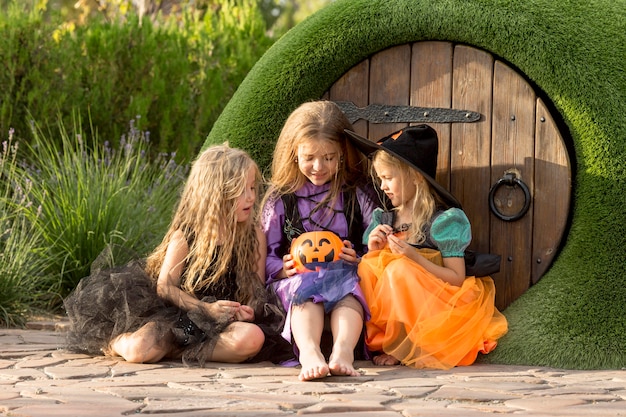 Free Photo front view of cute little girls with halloween costumes