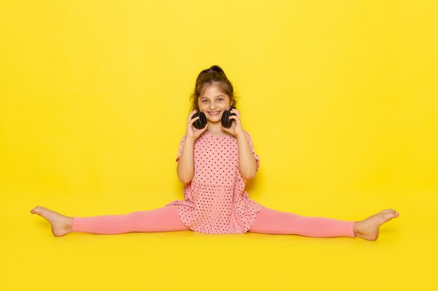 Free Photo a front view cute little kid in pink dress and black earphones