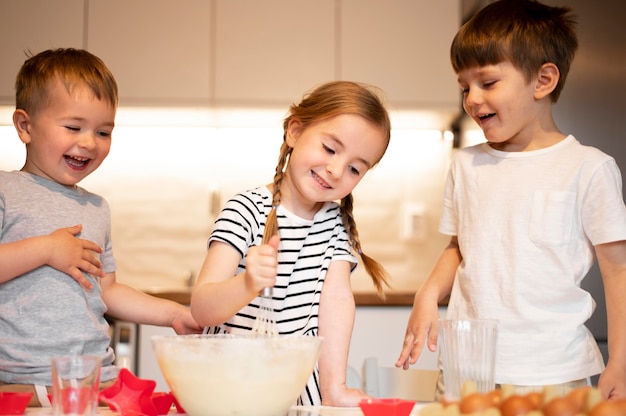 Front view of cute siblings cooking at home