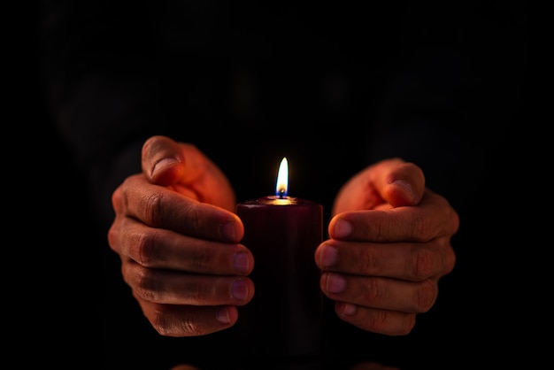 Front view of dark candle with male on a dark surface