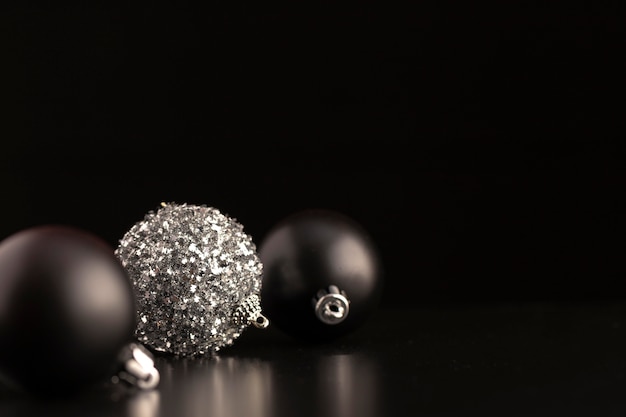 Free photo front view of dark christmas ornaments with copy space