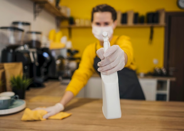 Free photo front view of defocused female barista with medical mask