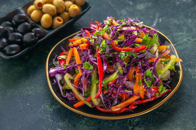 Front view delicious cabbage salad with peppers inside plate on dark background