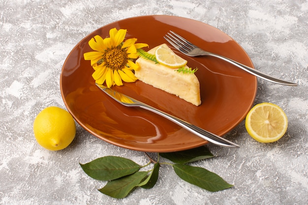 Free photo front view of delicious cake slice with lemon inside brown plate with forks on the light surface