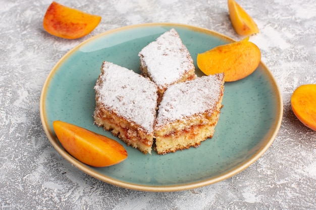 Front view delicious cake slices with sugar powder and fresh peaches inside plate on the table, cake biscuit sugar sweet pastry bake