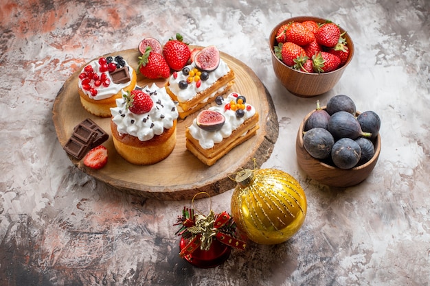 Free photo front view delicious cakes with fresh fruits on light background christmas cake dessert color biscuits