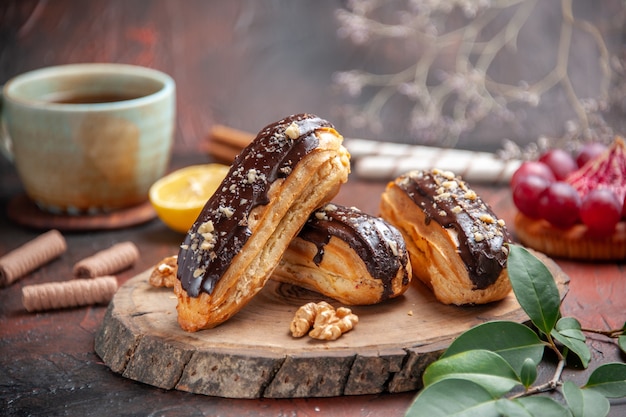 Free photo front view delicious choco eclairs on dark background