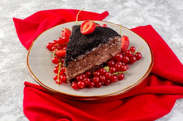 Front view of delicious chocolate cake sliced with choco cream and fresh red cranberries