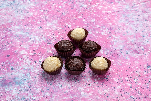 Free Photo front view delicious chocolate candies white and dark chocolate on pink background.