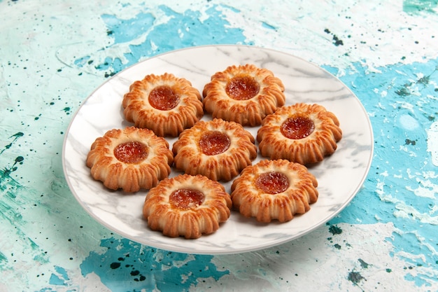 Front view delicious cookies round formed with jam inside plate on light-blue wall cookie sugar sweet biscuit dough cake bake