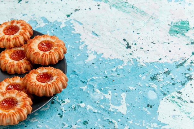 Front view delicious cookies with jam inside black plate on blue wall cookies biscuit sweet sugar color tea