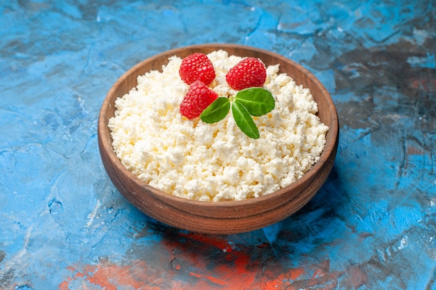 Front view delicious cottage cheese with fresh raspberries on blue background health white berry photo milk fruit color