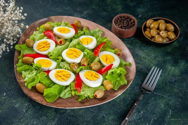 front view delicious egg salad consists of olives and green salad on dark background