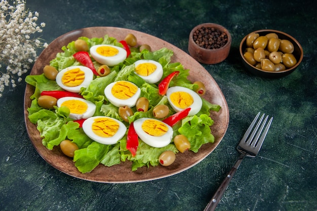 front view delicious egg salad consists of olives and green salad on dark background