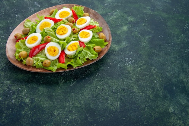 front view delicious egg salad with green salad and olives on dark blue background