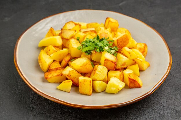 Front view delicious fried potatoes inside plate on dark table