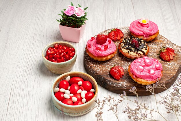 Front view delicious fruit cakes creamy desserts with candies and fruits on white background cream cookie dessert sweet cake tea