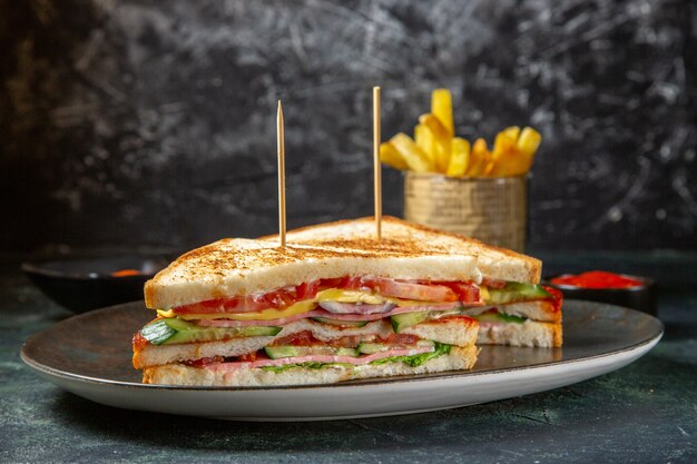 Front view delicious ham sandwiches inside plate with french fries dark surface