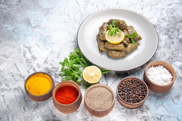 Free Photo front view of delicious leaf dolma with seasonings on white surface