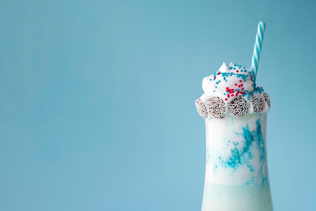 Free Photo front view of delicious milkshake on blue background