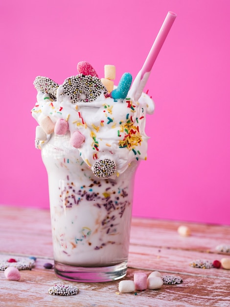 Front view of delicious milkshake on wooden table